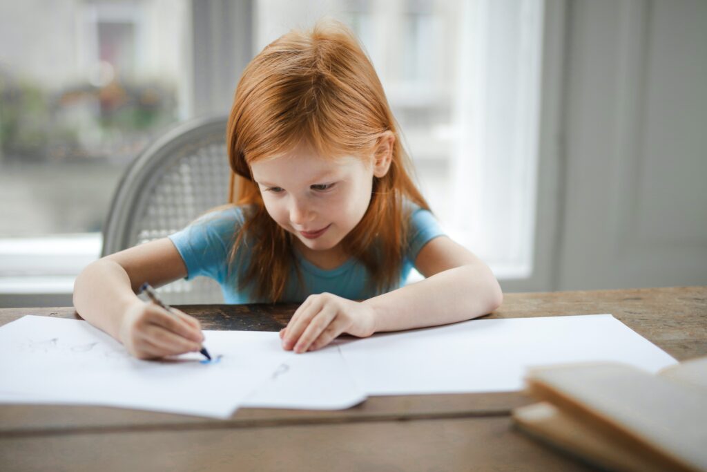 child using her proprioceptive sense to assist with the task of writing